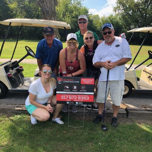 Big Boy's Construction employees at a golf event with two golf carts.