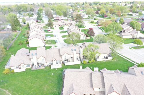 Aerial view of single family condos with light brown asphalt roofs installed - Big Boy's Construction