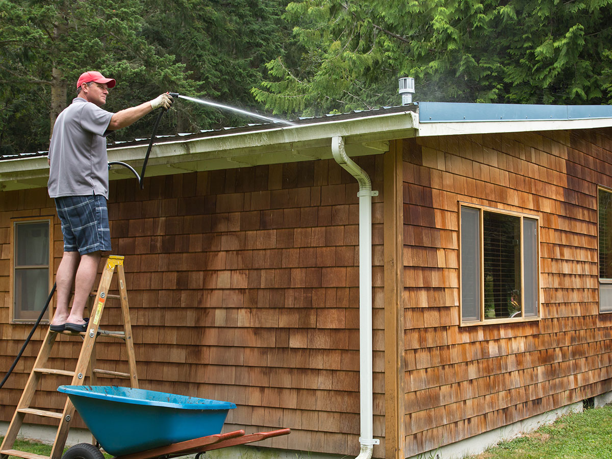 1200x900GMB-Maintaining Your Roof man spraying off roof