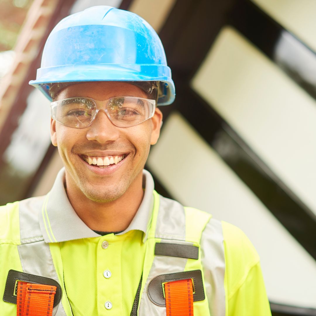 a smiling roofer wearing a construction helmet