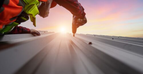 Man using drill on commercial roof