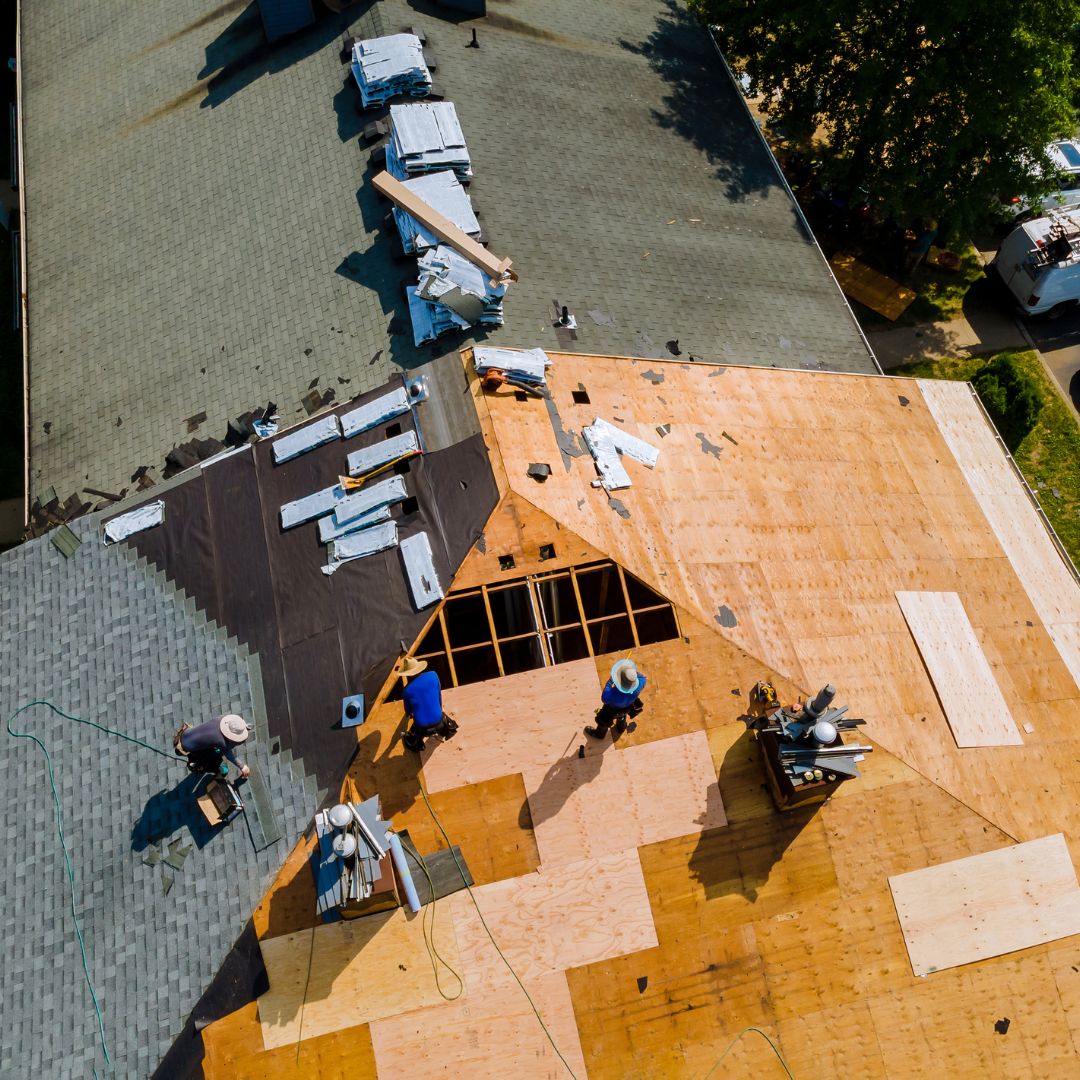 an aerial view of roofers replacing a roof