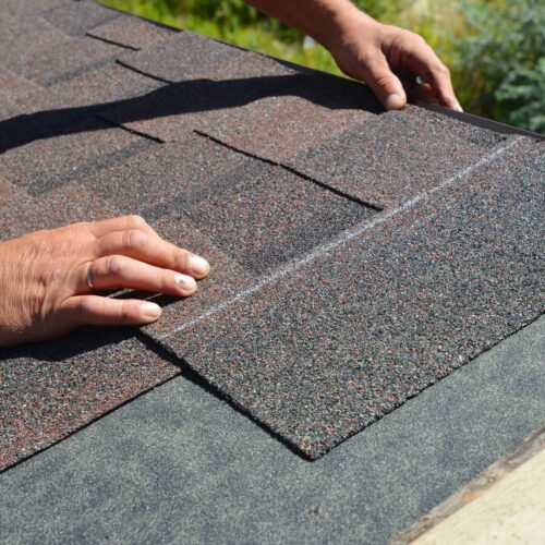 hands placing shingles