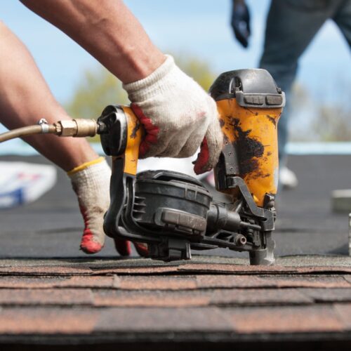 person installing shingles