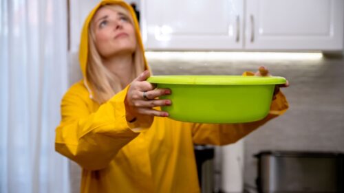 woman holding a bucket for roof leak